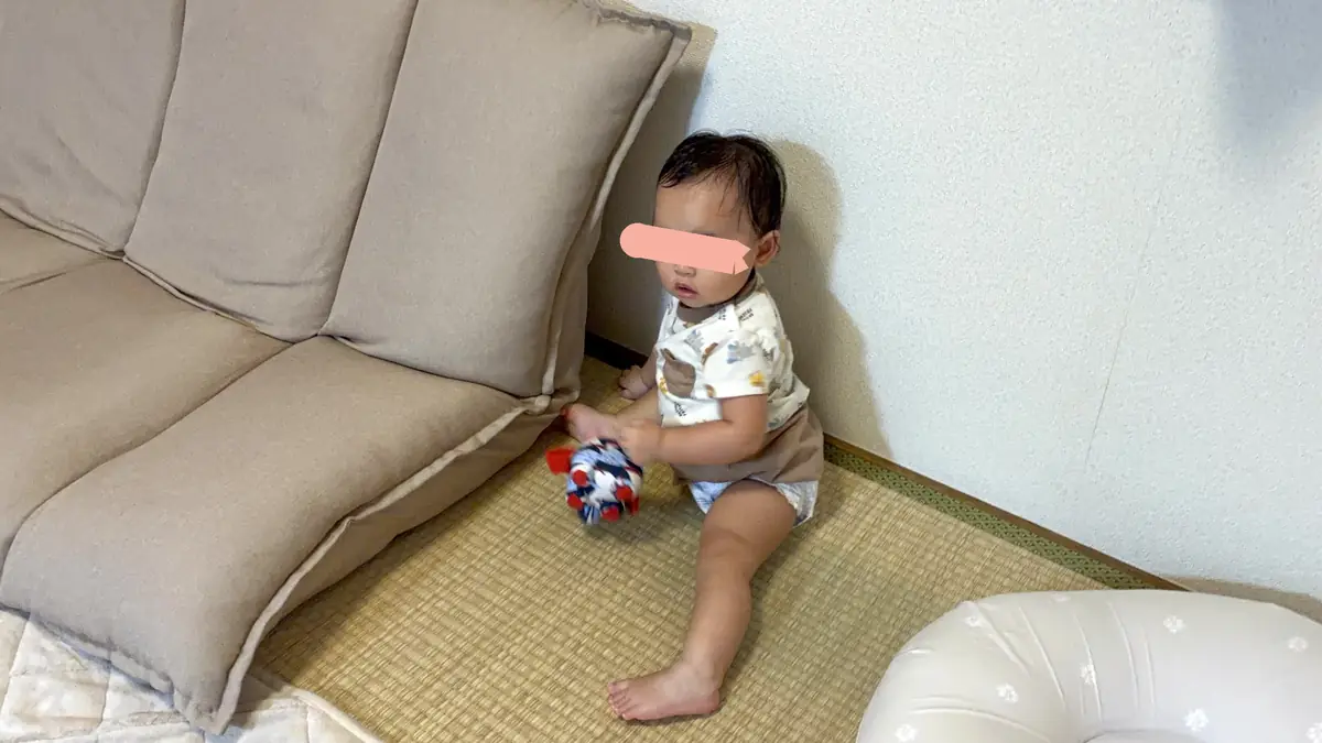 ボールを持ってソファの横に座る娘