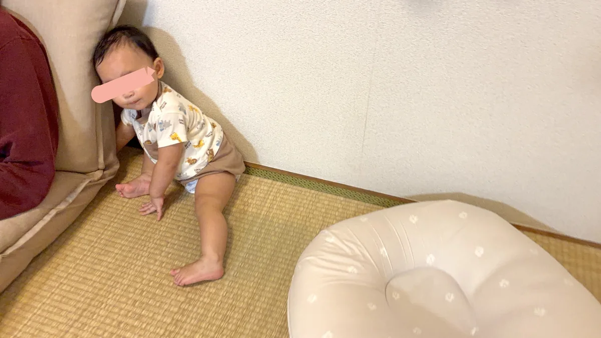 ソファのすき間に手を入れながら振り返る娘