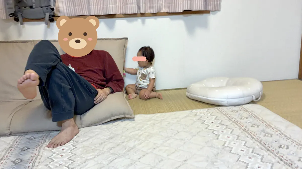 ソファでくつろぐ旦那と、ソファの横で遊ぶ娘