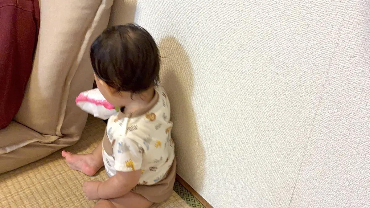 手口拭きシートの袋をソファのすき間に入れる娘