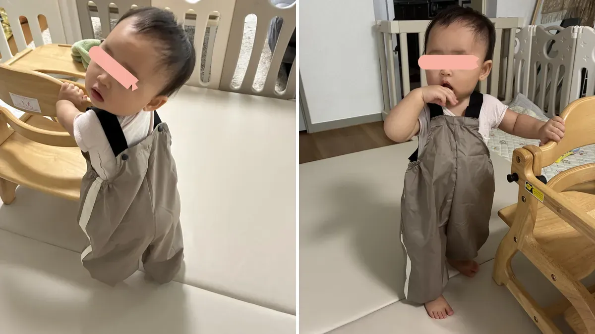サスペンダーつきの砂場着を着てつかまり立ちする七夕ちゃん