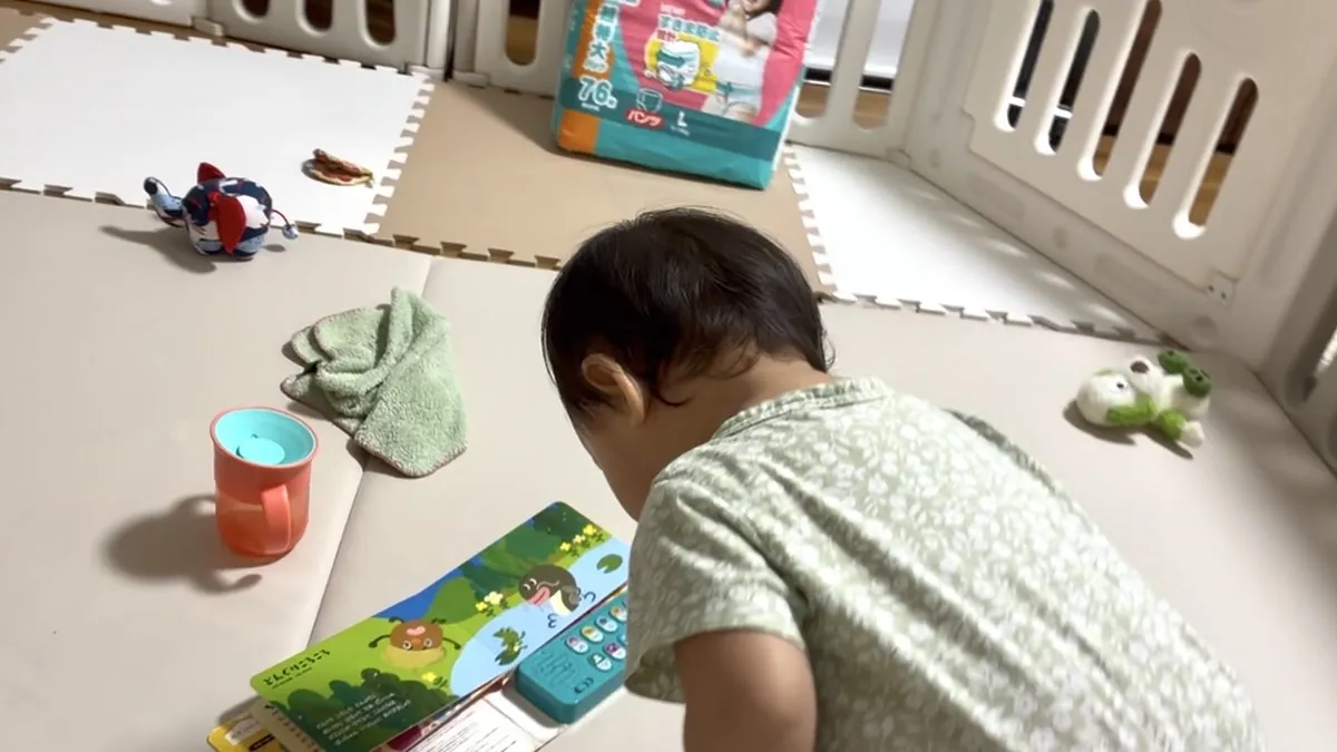 おうた絵本の「どんぐりころころ」のページを見る1歳3ヶ月の七夕ちゃん