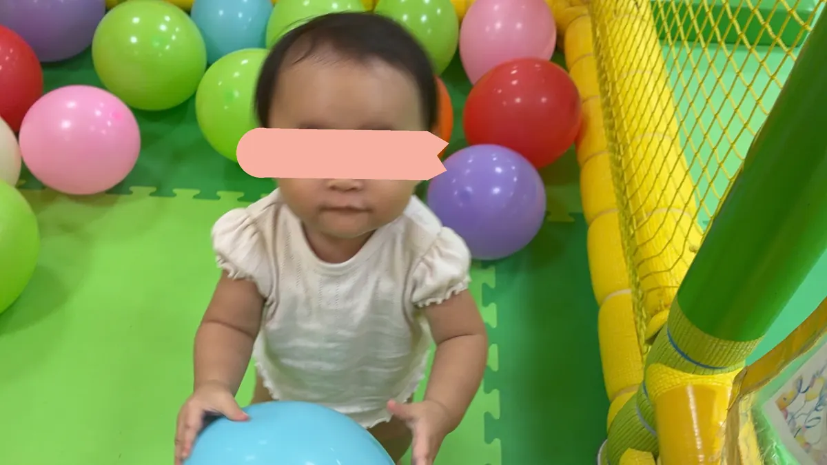 風船コーナーで風船をつかむ1歳の娘