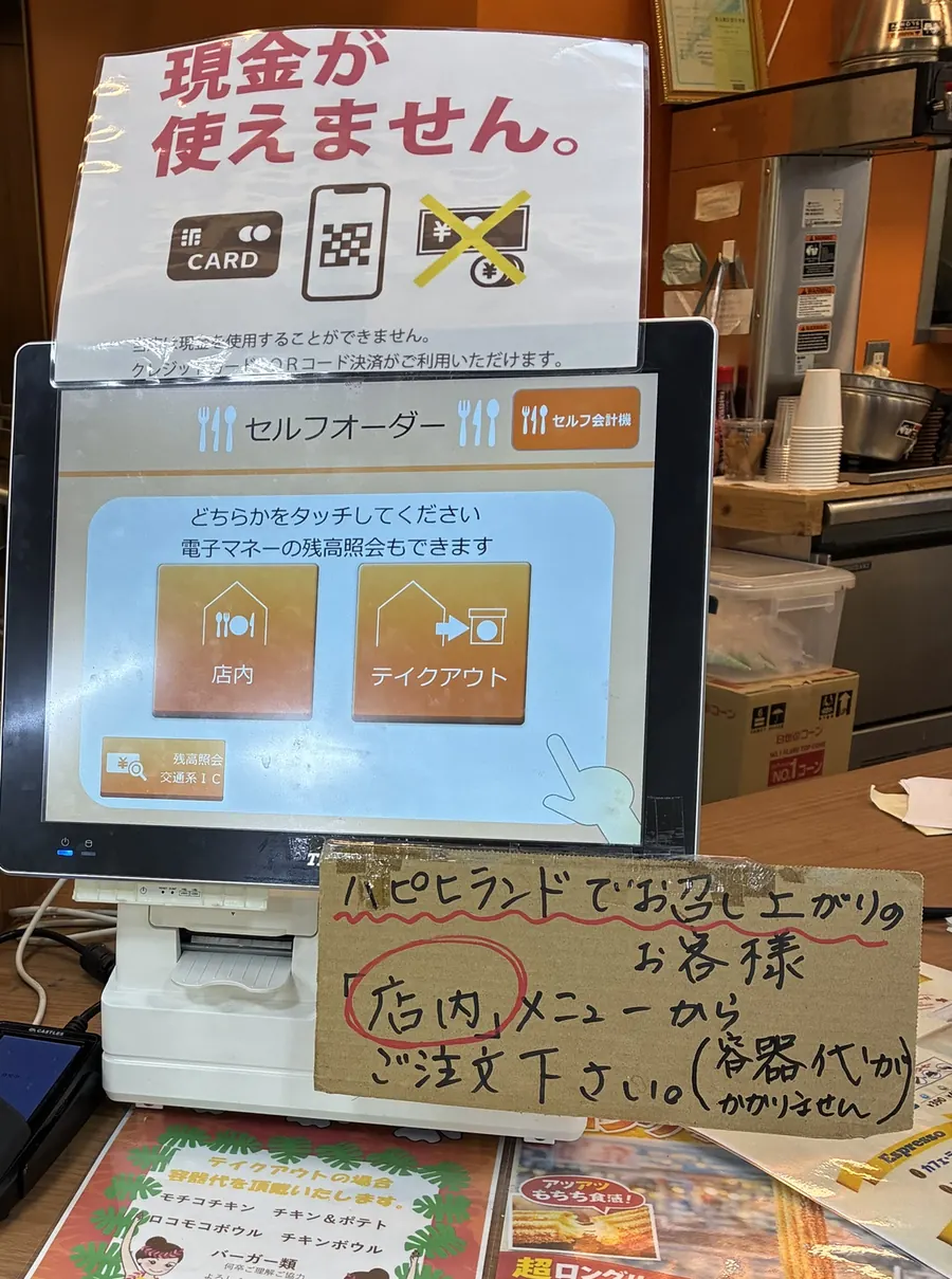 フードコーナーのセルフオーダー機と「現金が使えません」の案内