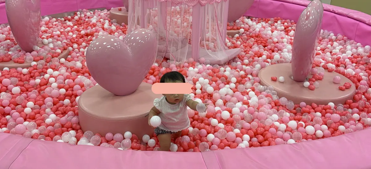 ピンクのハートプールで遊ぶ1歳の娘