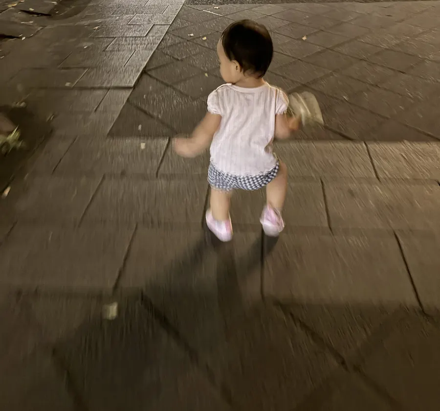 帰り道の夜道を歩く1歳の娘の後ろ姿