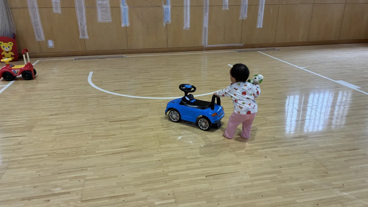 青いおもちゃの車を押して歩く七夕ちゃん