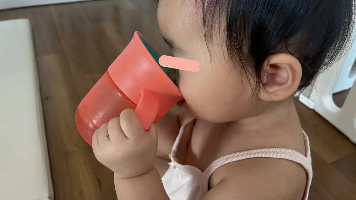 両手でミラクルカップを持って飲む娘