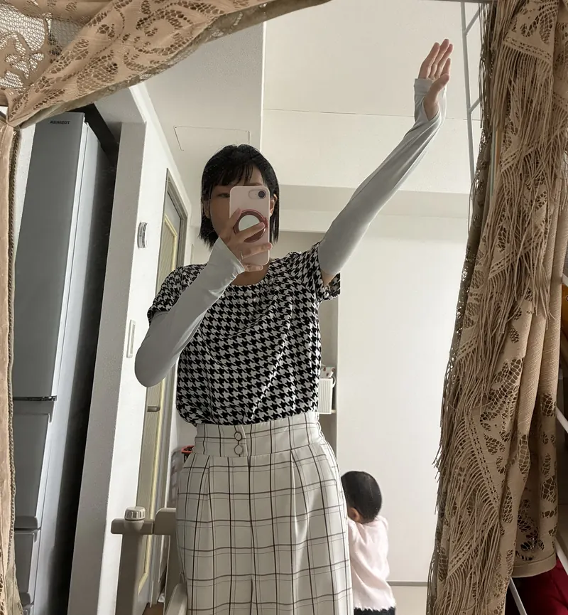 グレーのアームカバーを両腕に付けて鏡の前で撮った写真