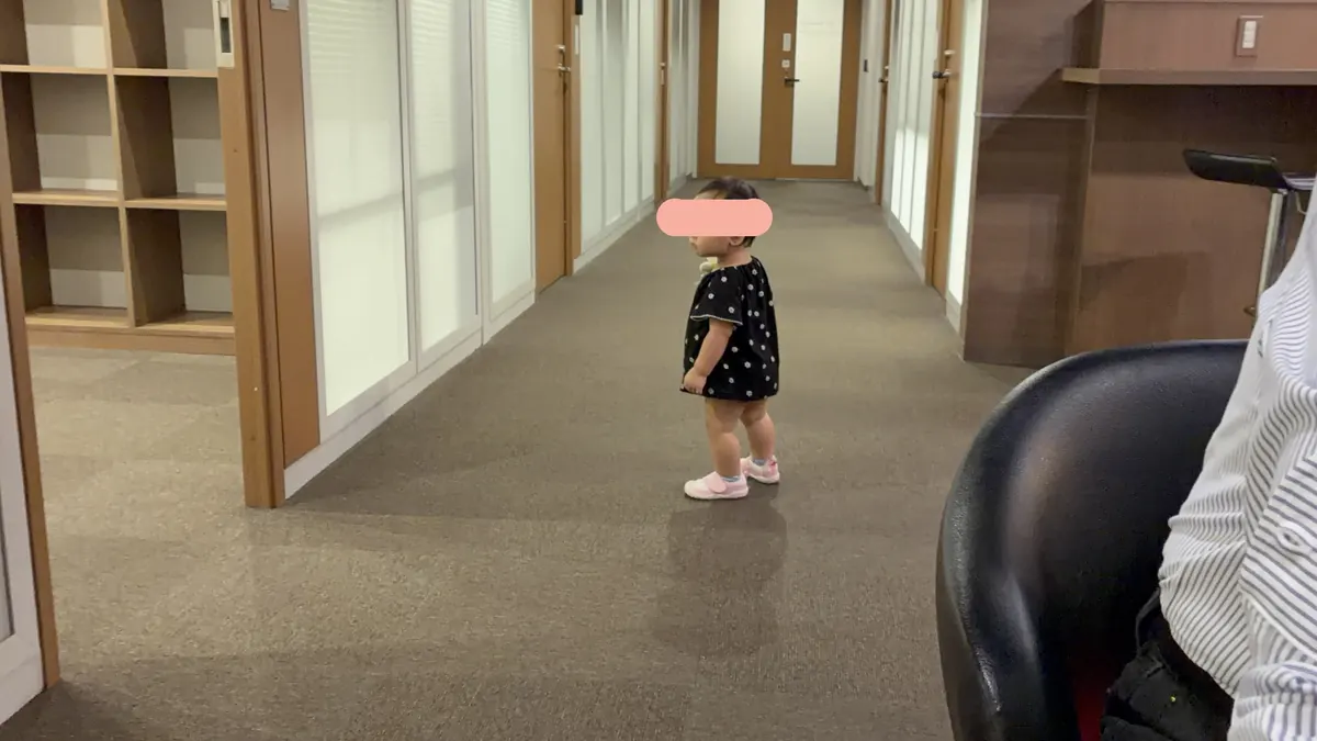 代表と話している間、あたりを歩き回る1歳の娘